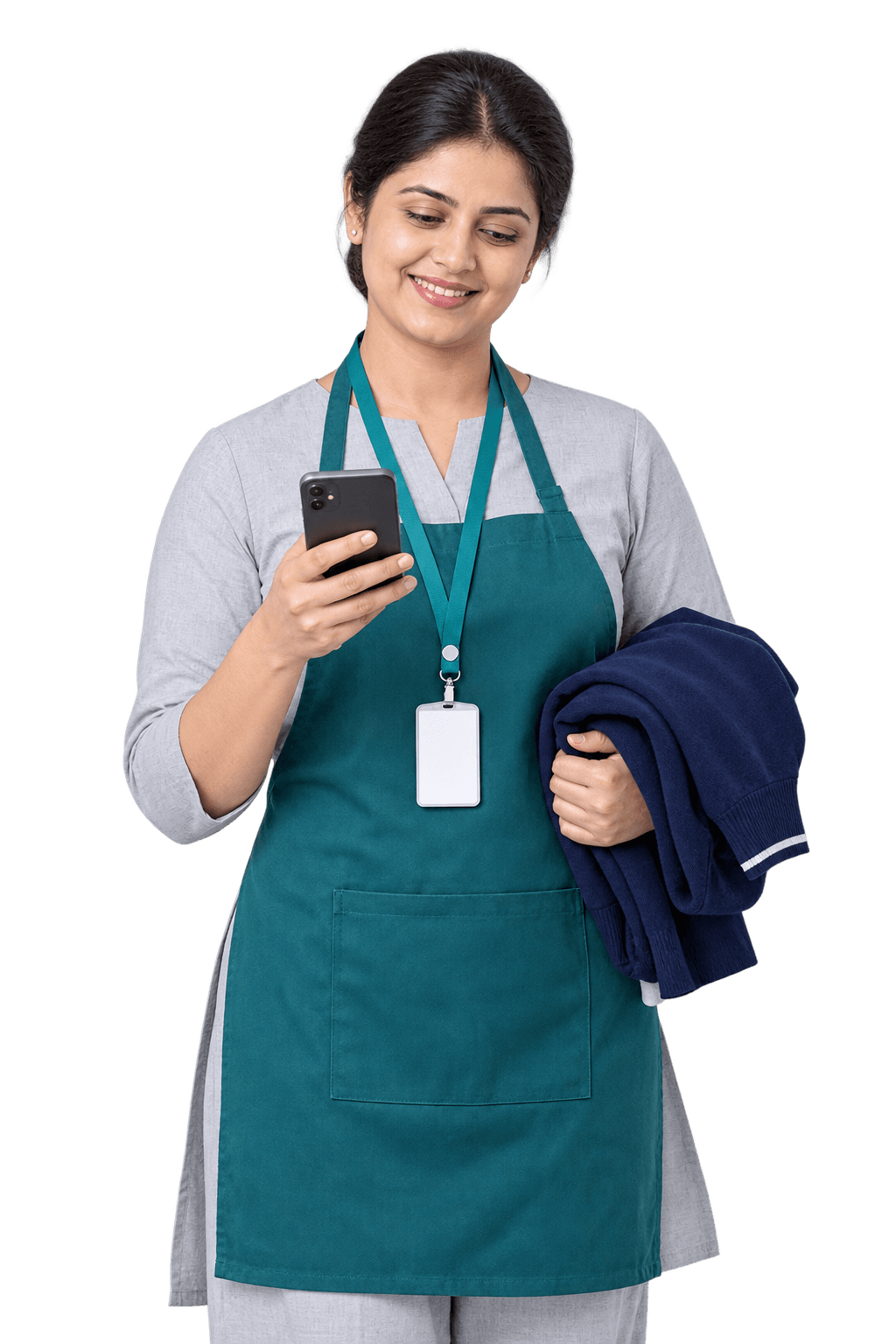Teal apron और staff ID में school store in-charge, हाथ में phone और तह किया हुआ uniform sweater